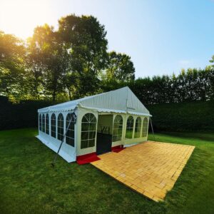 Hvidt festtelt på 6x6 meter opstillet på grøn græsplæne i Aalborg omgivet af træer.